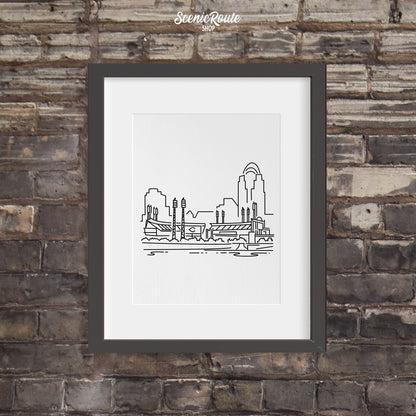 A framed line art drawing of the Cincinnati Reds Ballpark on a dark brick wall