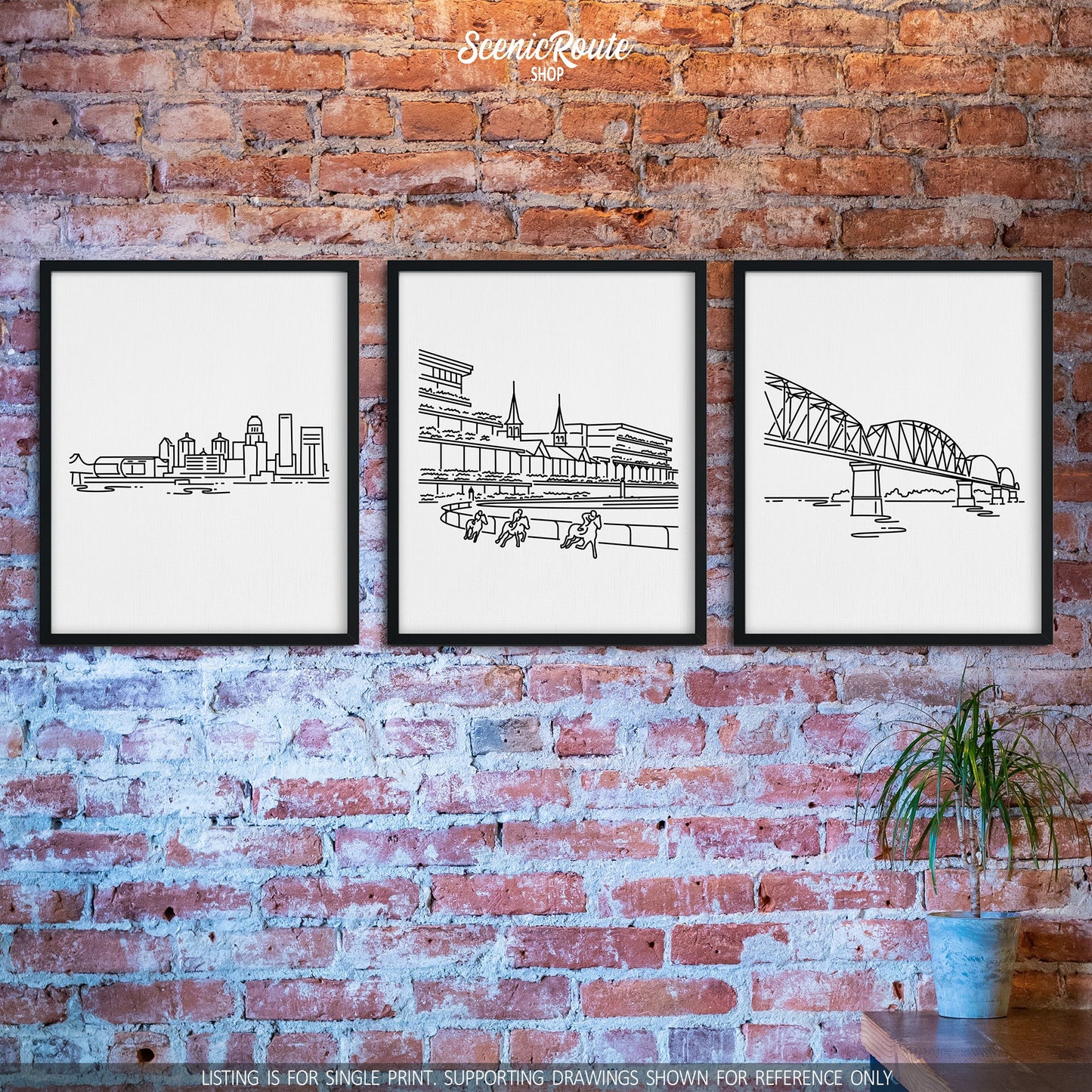 A group of three framed drawings on a brick wall. The line art drawings include the Louisville Skyline, Churchill Downs, and the Big Four Bridge