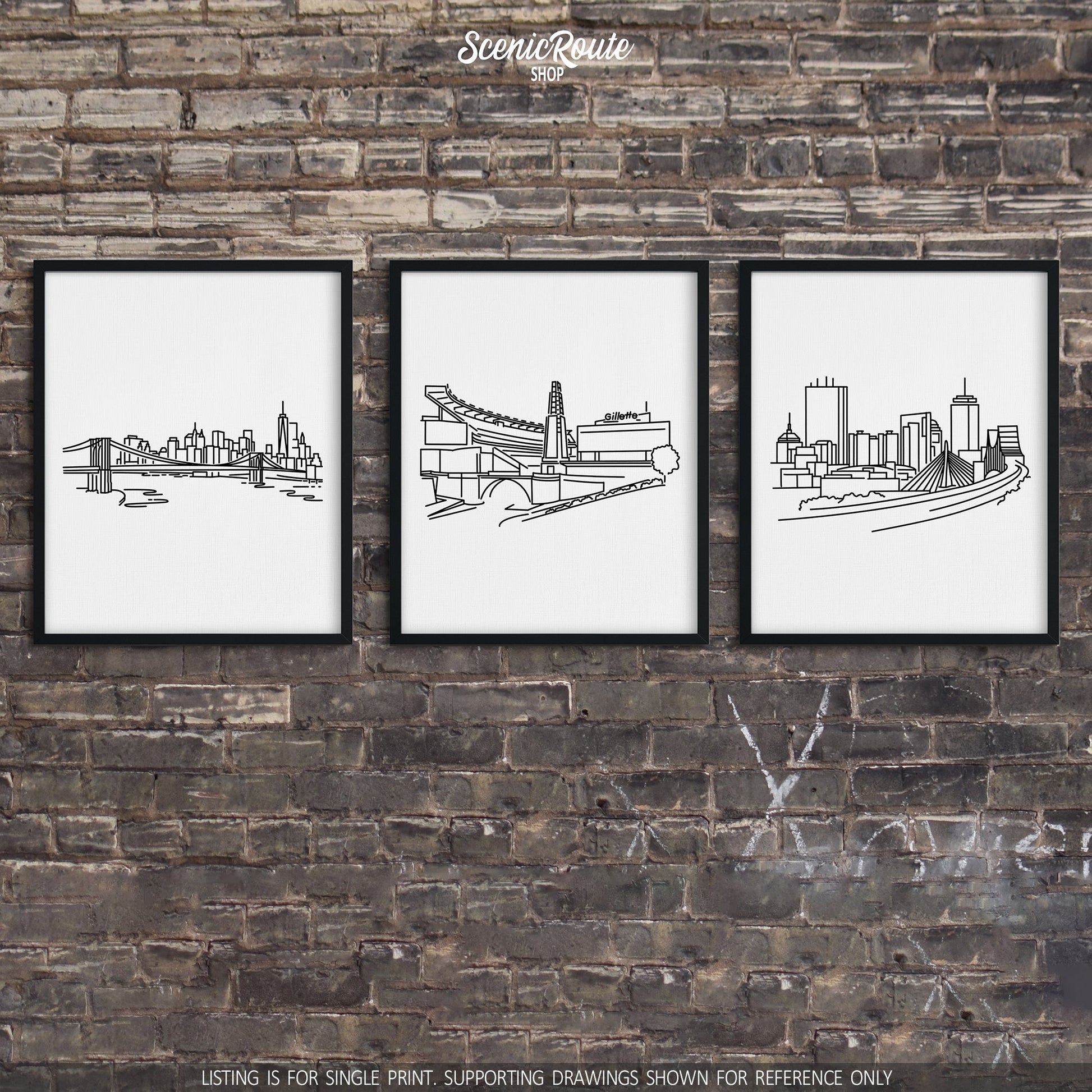 A group of three framed drawings on a brick wall. The line art drawings include the New York Skyline, Patriots Stadium, and Boston Skyline