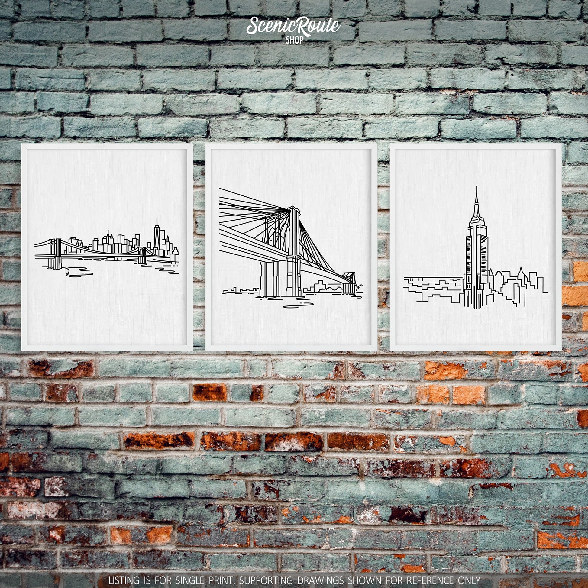 A group of three framed drawings on a brick wall. The line art drawings include the New York Skyline, Brooklyn Bridge, and Empire State Building