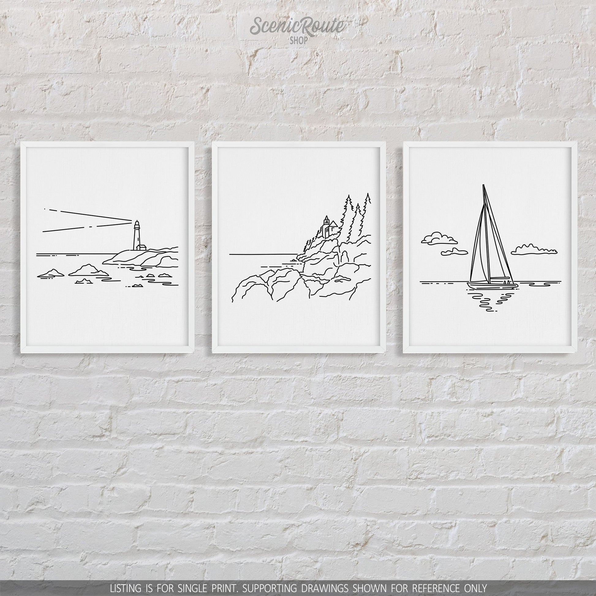 A group of three framed drawings on a brick wall. The line art drawings include a Lighthouse, Acadia National Park, and Sailing