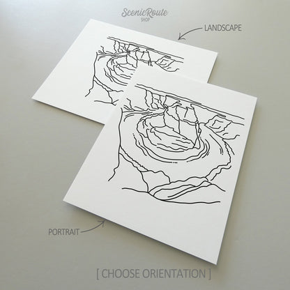 Two line art drawings of Horseshoe Bend on white linen paper with a gray background.  The pieces are shown in portrait and landscape orientation for the available art print options.