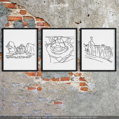 A group of three framed drawings on a brick wall. The line art drawings include Zion National Park, Horseshoe Bend, and Bryce Canyon National Park
