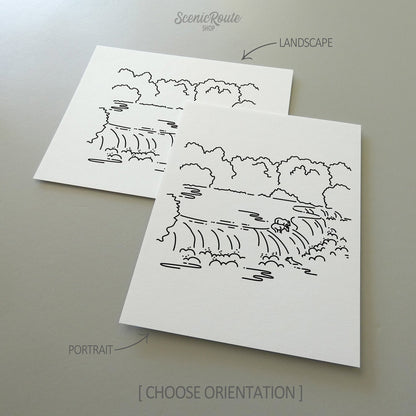 Two line art drawings of Katmai National Park on white linen paper with a gray background.  The pieces are shown in portrait and landscape orientation for the available art print options.