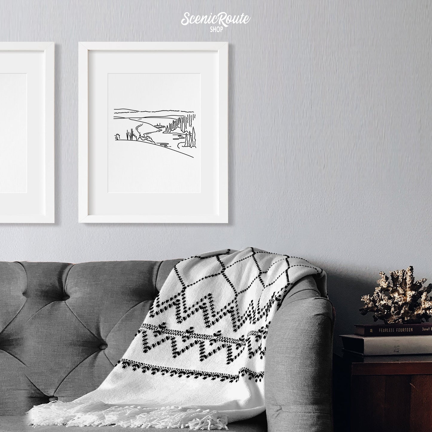 A framed line art drawing of Kobuk Valley National Park on a white wall above a couch