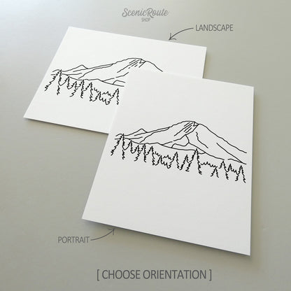 Two line art drawings of Mount Rainier National Park on white linen paper with a gray background.  The pieces are shown in portrait and landscape orientation for the available art print options.