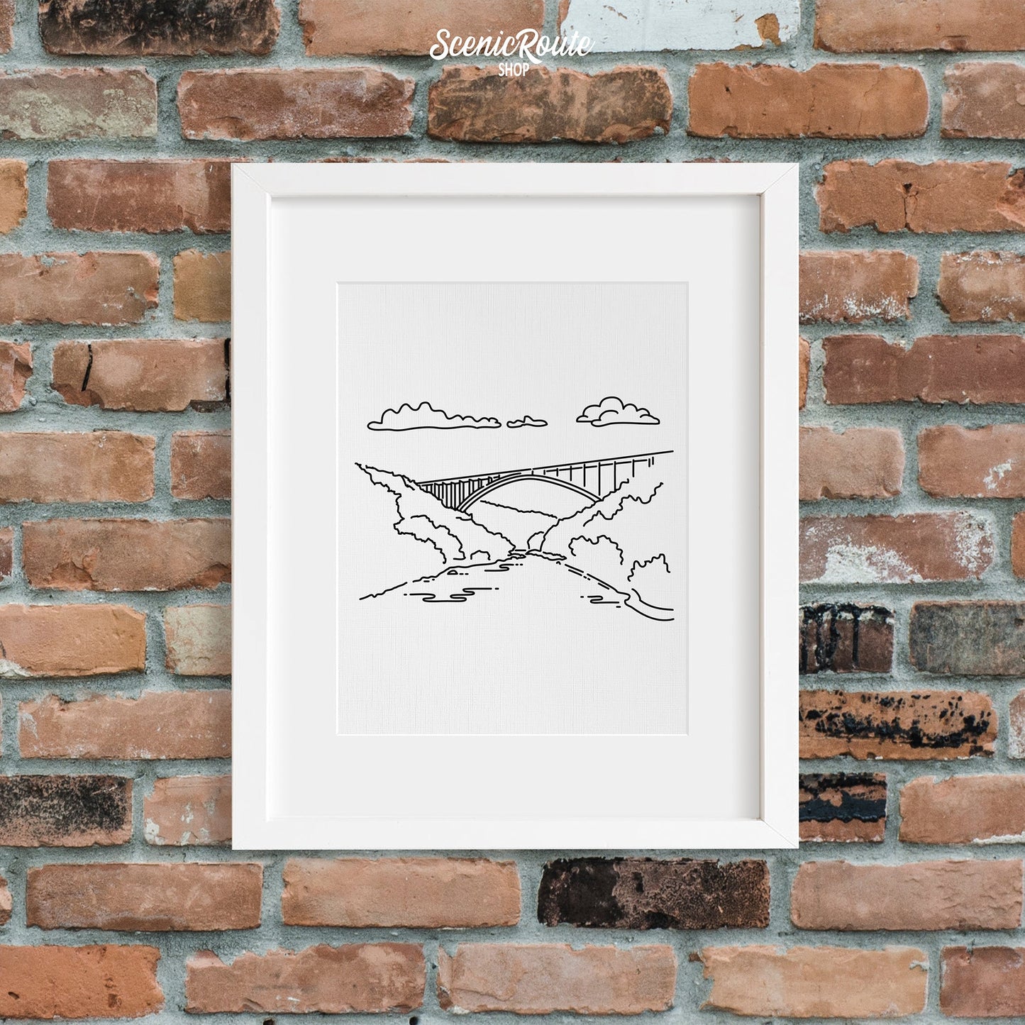 A framed line art drawing of New River Gorge National Park on a brick wall