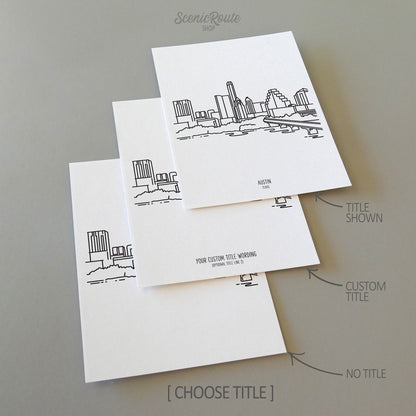 Three line art drawings of the Austin Texas Skyline on white linen paper with a gray background. The pieces are shown with title options that can be chosen and personalized.